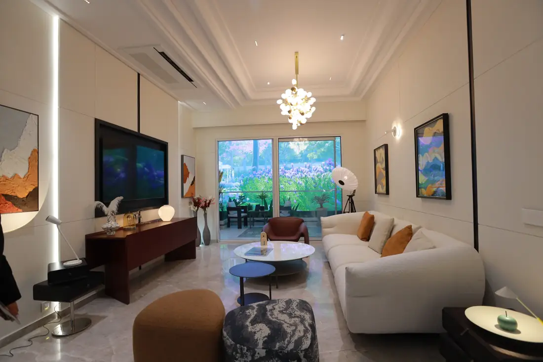 Living room with marble flooring and garden-facing glass doors at VVIP Addresses